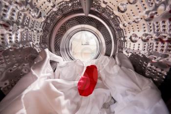 View Looking Out From Inside Washing Machine With Red Sock Mixed With White Laundry
