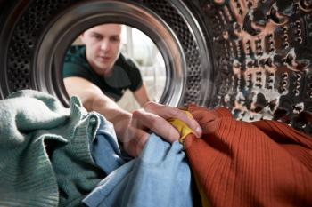 View Looking Out From Inside Washing Machine As Young Man Does Laundry