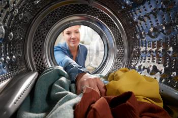 View Looking Out From Inside Washing Machine As Young Woman Does Laundry
