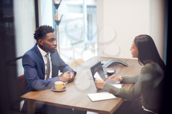 Businesswoman Interviewing Male Job Candidate In Meeting Room