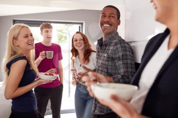 Group Of College Students In Shared House Kitchen Eating Breakfast Together