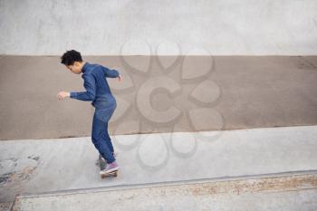 Young Woman Riding On Skateboard In Urban Skate Park