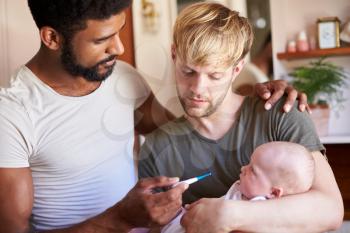 Male Same Sex Couple Checking Baby Daughters Temperature In Bathroom At Home