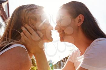 Female Gay Couple Outside House About To Kiss Against Flaring Sun