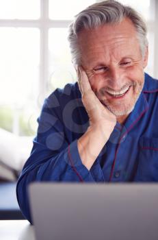 Mature Man Having Online Consultation With Doctor At Home On Laptop
