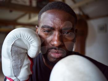 Close Up Portrait Of Male Boxer Wearing Gloves Standing In In Gym