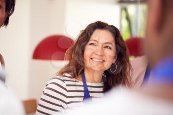 Smiling Mature Woman Wearing Apron Taking Part In Cookery Class In Kitchen