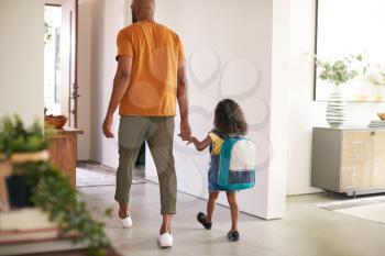 Rear View Of Father Holding Daughters Hand As She Leaves Home For School