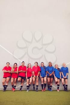 Graphic Shot Of Womens Football Team Leaning Against Wall Whilst Training For Soccer Match
