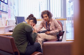 Female College Student Meeting With Campus Counselor Discussing Mental Health Issues