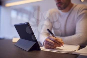 Close Up Of Man In Kitchen Working Or Studying From Home Using Digital Tablet