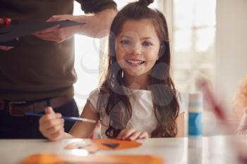 Portrait Of Daughter At Home With Father Having Fun Making Craft Together