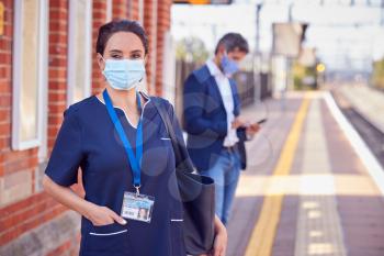 Portrait Of Nurse On Railway Platform Wearing PPE Face Mask Commuting To Work During Pandemic