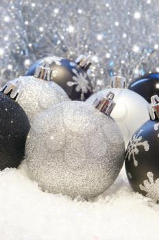 Silver and black Christmas decorations in snow