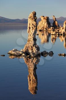 Magic sunset on Mono lake . Ancient lake in a crater of an extinct volcano. Tufa stalactites are reflected in smooth water of lake