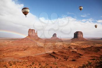 Balloons under storm clouds. Monument Valley. The magnificent rainbow over the famous red sandstone Mittens
