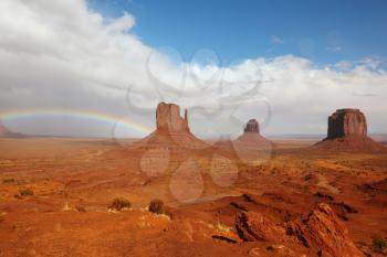 Rainbow in a red desert. The famous Mittens in Monument Valley after the rain