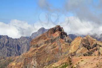  A narrow footpath above the cliffs of stone. The highest peak of Madeira Island - Pico Ruyvu.