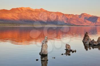 Extremely beautiful landscape. Mono Lake on a sunset. Lake stalagmites of the Tufa are reflected in smooth water of lake