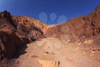 The marked tourist route in ancient mountains of Sinai desert. Sunrise over Red sea