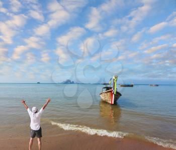 Happy man joyfully welcomes the sunrise. A picturesque ocean bay in the Thai gulf