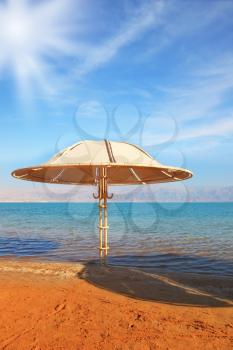 Medical beach on the Dead Sea, Israel. Round gazebo leaves deep shadow.