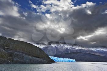 Journey to the End of the World. Chilean Patagonia in the clouds and sunshine. Blue Ice Glacier Gray is reflected in the lake