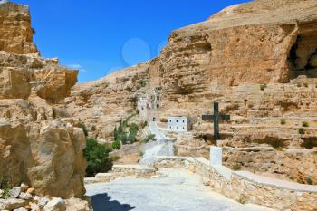 The famous monastery of St. George Cozeba. The road leading to the temple. The building of the monastery was built on the wall of the gorge of Wadi Kelt near Jerusalem. The guiding signpost - Black Cr