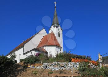 Church clearly look elegant against the clear blue sky. Church built on a hill and surrounded by flowers