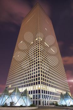 Skyscraper of the unusual triangular form in business part Tel-Aviv on a background of pink night clouds