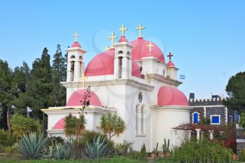 White walls, pink domes and golden crosses the Orthodox Church of the Twelve Apostles. The shore of Lake Kinneret.
