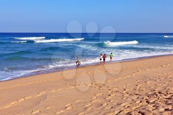 SINTRA, PORTUGAL - OCTOBER 2, 2011: Four young athletes are doing morning jog on the ocean beach. One girl doing a handstand