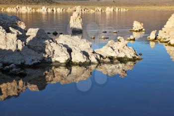 Extremely beautiful landscape. Mono Lake on a sunset. Lake stalagmites of the Tufa are reflected in smooth water of lake
