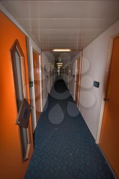  The long corridor in inexpensive tourist hotel and a door of rooms