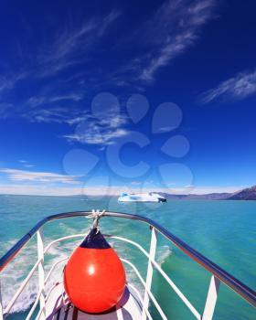  White-blue huge icebergs float near a ship board. Ice and sun Patagonia. Excursion on the tourist boat on Lake Viedma