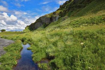Neighborhood Seljalandsfoss. Iceland in July. Green meadows and clear streams