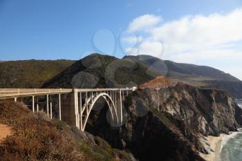 Huge viaduct on mountain road on Pacific coast USA. Bright serene autumn day
