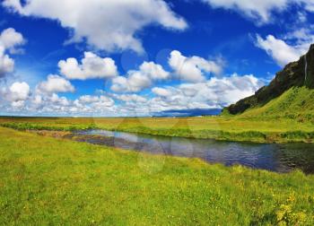 Iceland in July. Green fields and streams near the giant ice plateau