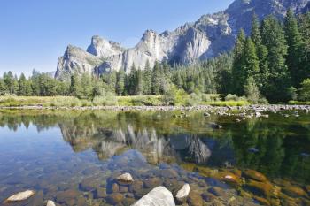 The magnificent Yosemite Valley. Three scenic rocky peaks and reflected in the smooth waters of the Merced