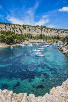 White sailing yacht waiting for their owners.  National Park Calanques on the Mediterranean coast.  The picturesque narrow fjords between the rocky shore 