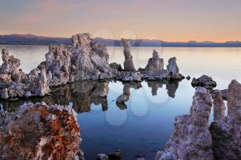 The magic of Mono Lake. Outliers - bizarre limestone calcareous tufa formation on the smooth water of the lake