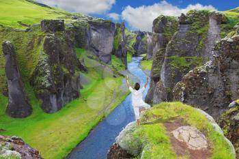 Fantastic country Iceland. Woman performs asana Tree on a rock canyon  Fjadrargljufur