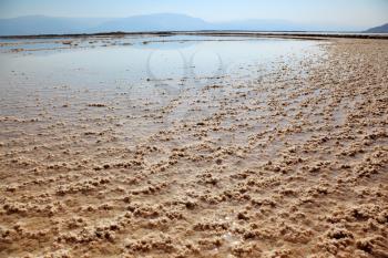 The condensed salt out over a water surface. The shoaled Dead Sea at coast of Israel