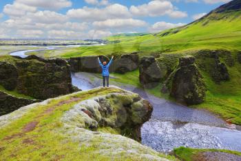 Fantastic country Iceland. Enthusiastic woman - tourist on a rock canyon  Fjadrargljufur