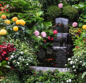 Gorgeous three-stage fountain surrounded by flowers. Butchart Garden Park on Vancouver Island, Canada