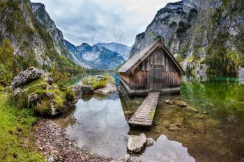 The concept of active tourism and ecotourism. Enchanted Lake Obersee in the Bavarian Alps. Boat garage in the middle of the lake