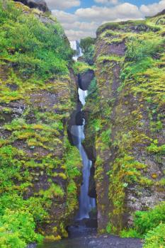 Abounding scenic waterfall inside a cave near Selyalandfoss. Iceland, July