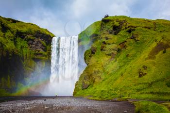 Magnificent famous waterfall Skógafoss, Iceland. A powerful jet Skógar River forms a large rainbow.