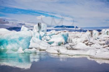  Floating ice and clouds reflected in the mirror-smooth water lagoon Ice Jokulsarlon. Ice splendor. Iceland