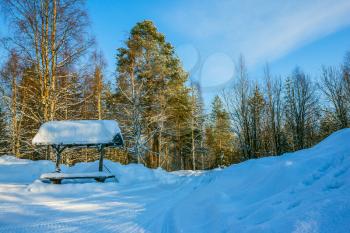 Snowy winter in the Arctic. At the bus stop is a large snowdrift. Travel to Lapland. Winter fairy tale in a sunny frosty day. The concept of active and extreme tourism